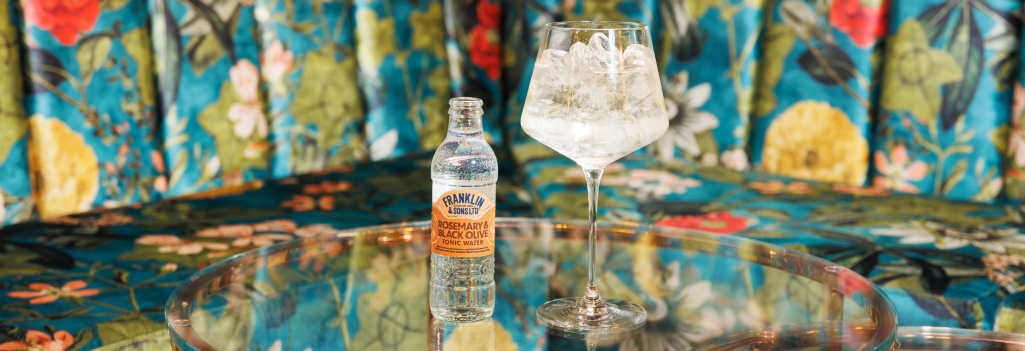 Rosemary spritz cocktail in a wine glass with a patterned floral background | Franklin & Sons